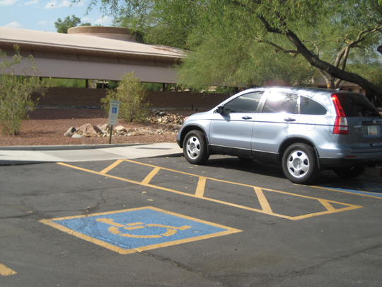 This after photograph shows the removal of the non-complying 'protruding curb ramp', and the completion of a fully accessible parking space, with compliant curb ramp.